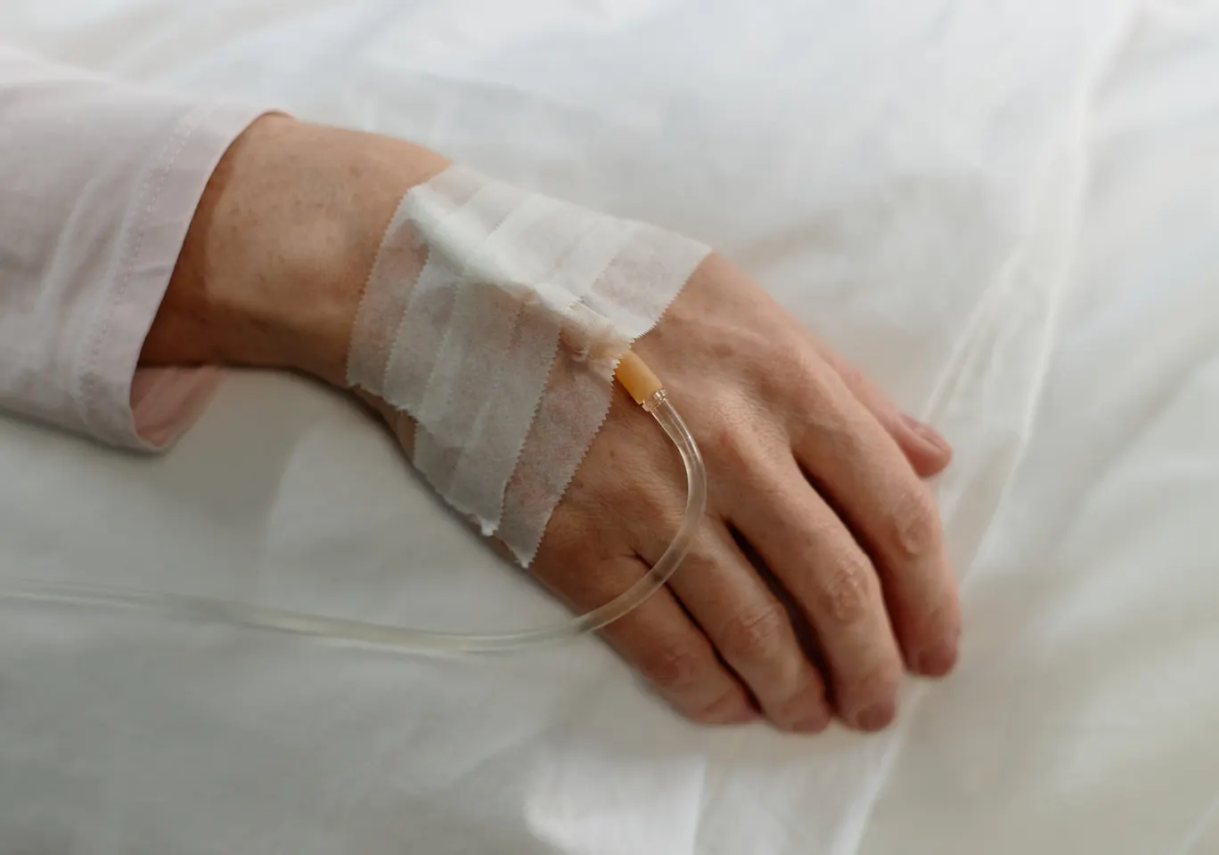 Kroplówki witaminowe Kłobuck: dłoń z podłączoną kroplówką w spokojnym kadrze