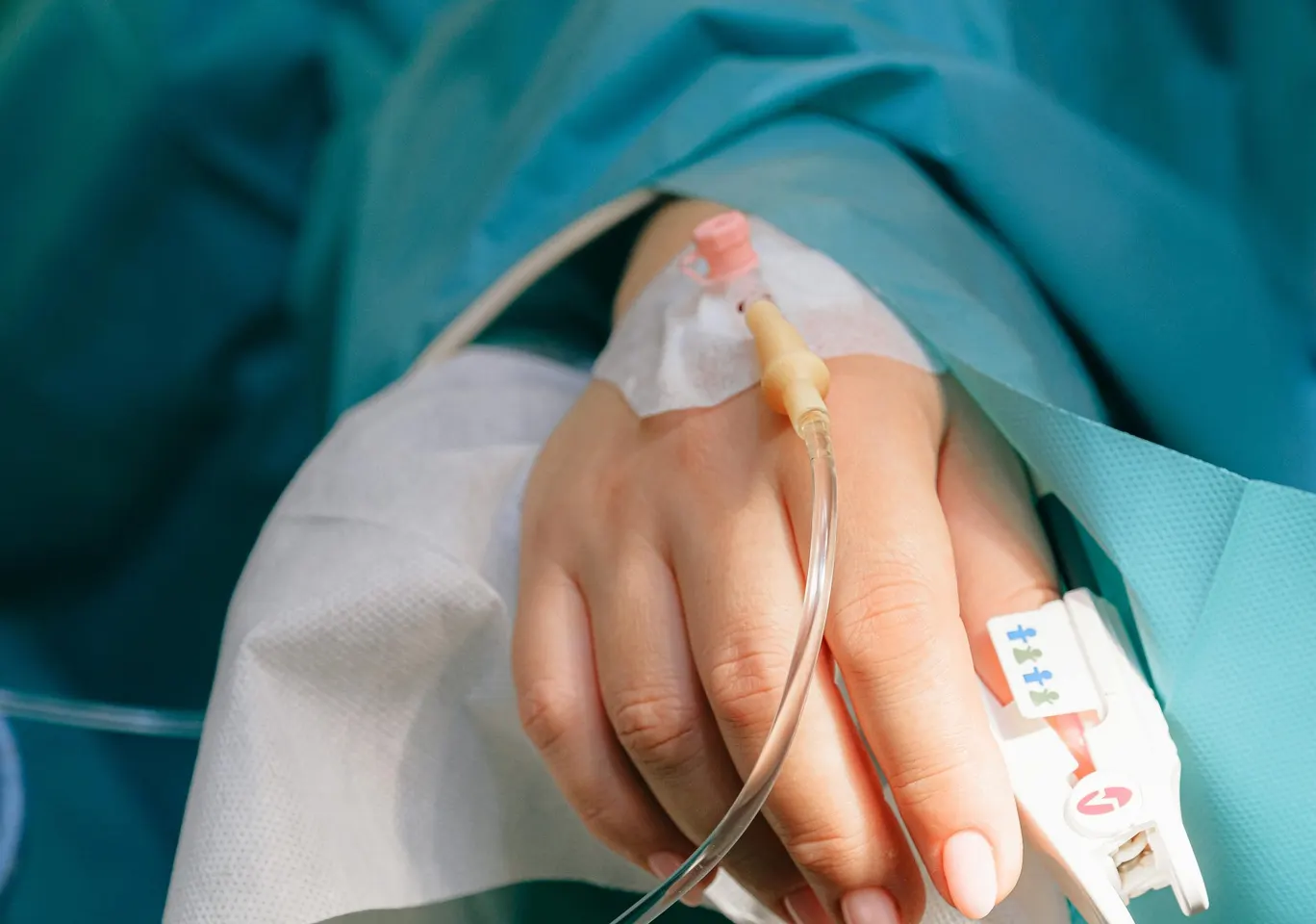 Detoks alkoholowy Kłobuck: dłoń z wenflonem i pulsoksymetrem pod nadzorem